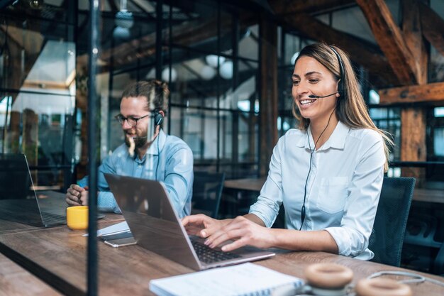 Smiling group of diverse businesspeople working together around a meeting table in an office complex lobby