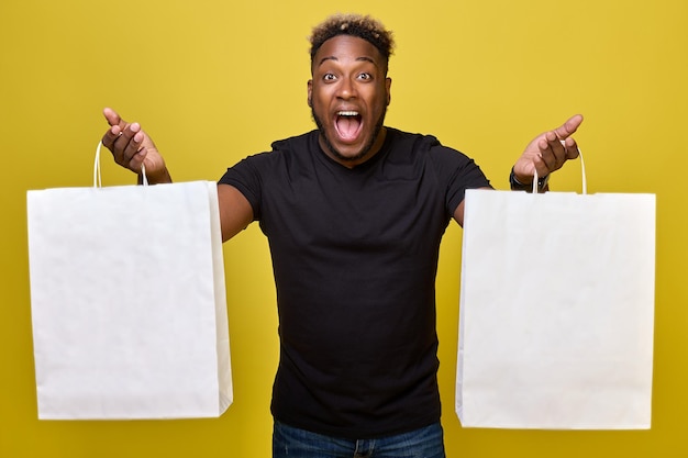 Smiling guy demonstrates his bargains made on the days of big discounts