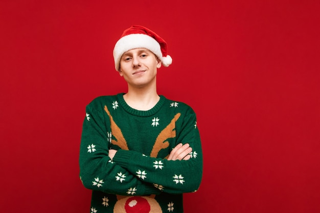 Photo smiling guy with christmas mood isolated on red background