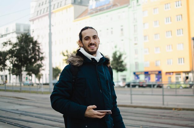 Photo smiling guy with long hair traveling in europe during winter time - vienna austria