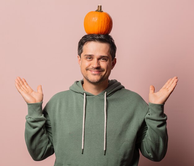 Smiling guy with pumpkin on pink