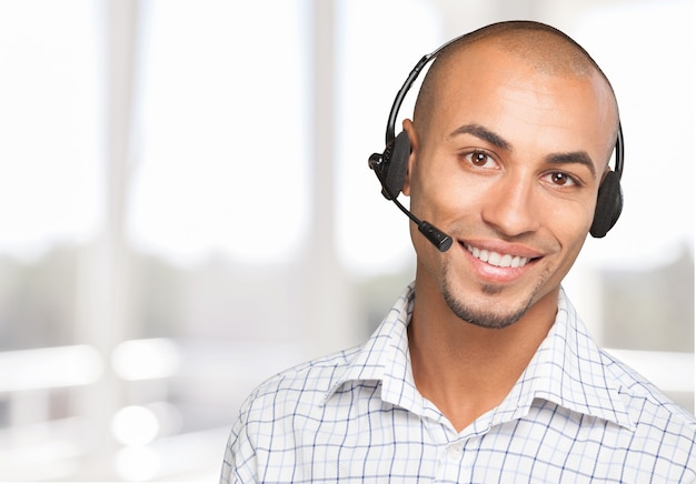 Smiling handsome businessman wearing headset looking at camera isolated on white