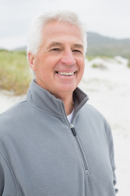 Smiling handsome casual senior man at beach