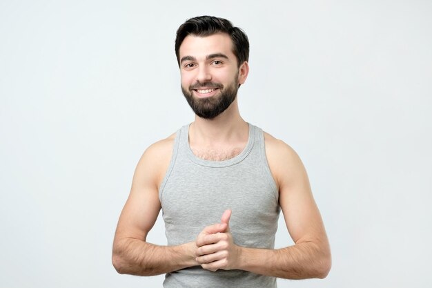 Smiling handsome man in singlet standing smiling