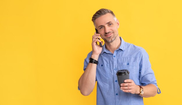 Smiling handsome man use smartphone with coffee cup man drinking coffee