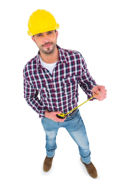 Smiling handyman holding tape measure 