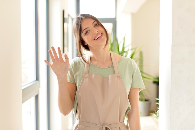 smiling happily and cheerfully, waving hand, welcoming and greeting you, or saying goodbye