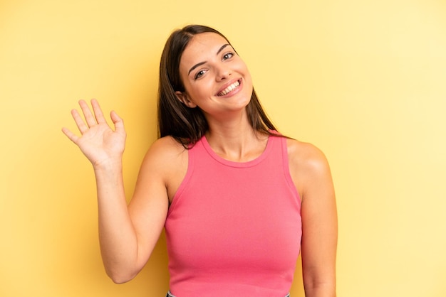 Smiling happily and cheerfully waving hand welcoming and greeting you or saying goodbye