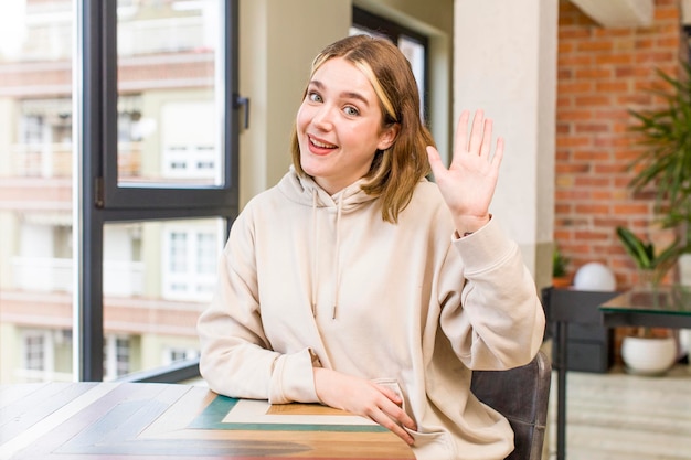 Smiling happily and cheerfully waving hand welcoming and greeting you or saying goodbye