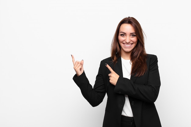 smiling happily and pointing to side and upwards with both hands showing object