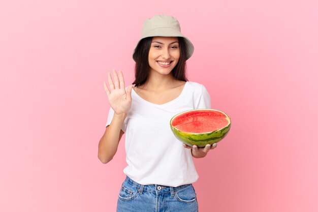 Sorridendo felicemente, agitando la mano, dandoti il benvenuto e salutandoti