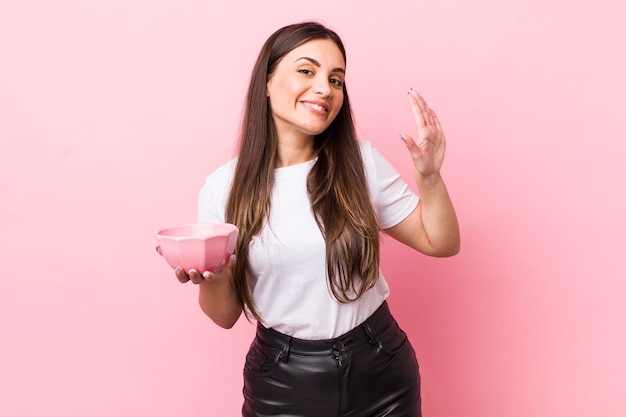 Sorridendo felicemente agitando la mano accogliendoti e salutandoti