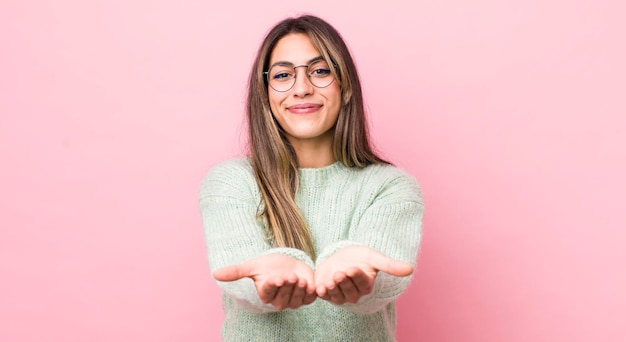 Foto sorridendo felicemente con uno sguardo positivo e fiducioso che offre e mostra un oggetto o un concetto