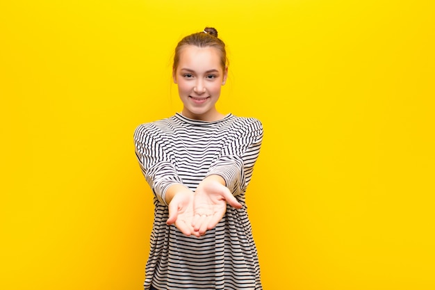 Foto sorridendo felicemente con uno sguardo amichevole, fiducioso, positivo, offrendo e mostrando un oggetto o un concetto