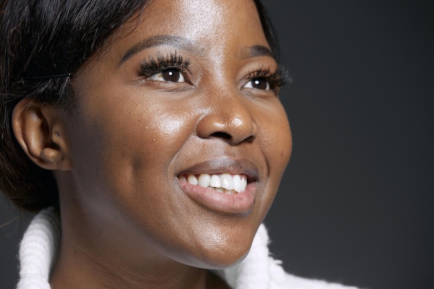 Smiling happy african american woman with long lashes look up closeup natural beauty makeup candid