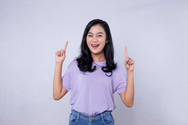 Smiling happy asian woman with her finger pointing isolated on light white banner background with copy space