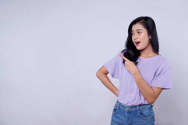 Smiling happy asian woman with her finger pointing isolated on light white banner background with copy space