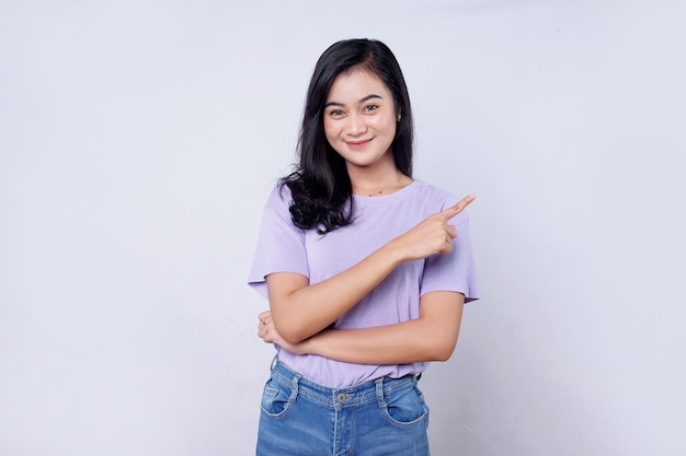 Smiling happy asian woman with her finger pointing isolated on light white banner background with copy space