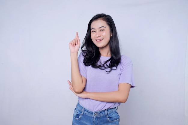 Smiling happy asian woman with her finger pointing isolated on light white banner background with copy space
