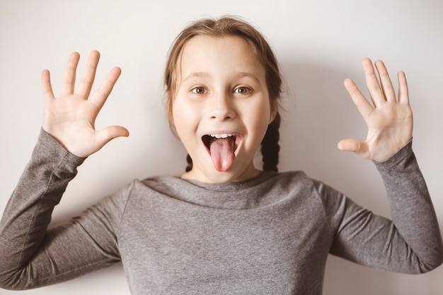 Smiling and happy child girl showing tongue