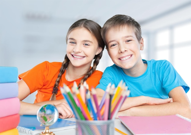 Smiling Happy children sitting by the table during lesson