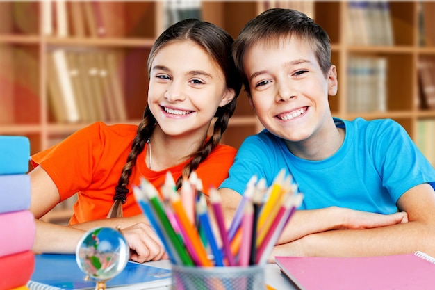 Smiling Happy children sitting by the table during lesson