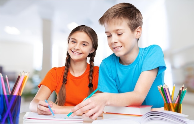 Smiling Happy children sitting by the table during lesson