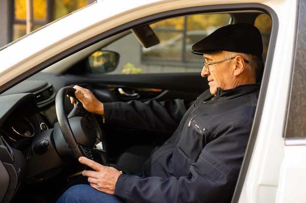 Photo smiling happy elderly man in the new car