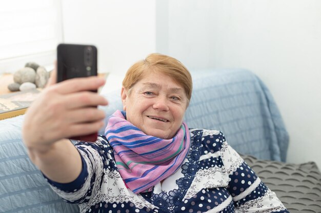 Smiling happy elderly woman at home takes a selfie Lifestyle Positive emotions