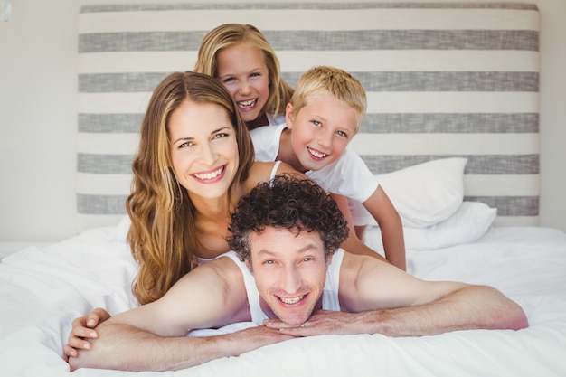 ベッドの上の笑顔の幸せな家族