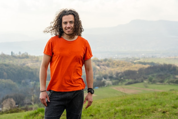 Smiling and happy man standing on the mountain