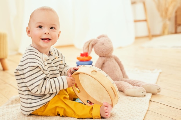 Foto bambino sano sorridente che gioca con i giocattoli di legno colorati a casa