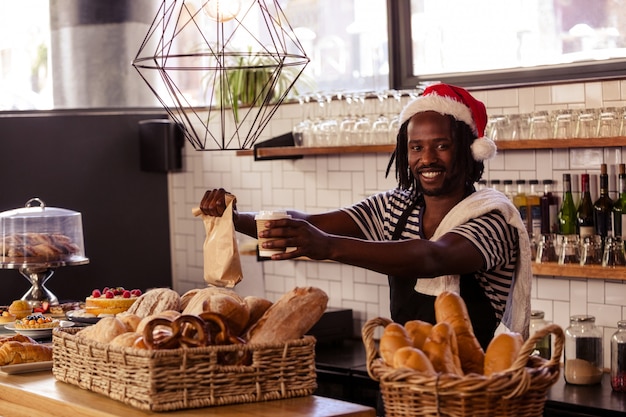 Smiling hipster employee serving take away products