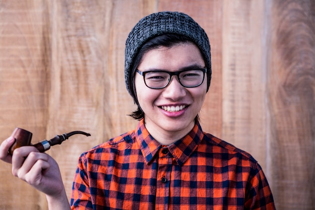 Photo smiling hipster holding pipe