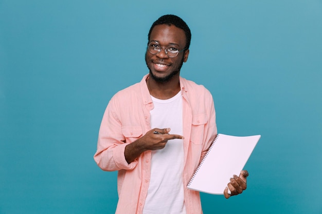 Sorridente in possesso di carta giovane ragazzo afroamericano isolato su sfondo blu