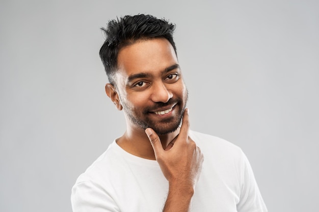 smiling indian man touching his beard