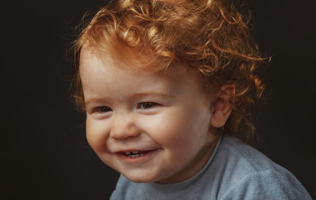 Smiling infant cute smile caucasian baby portrait close up kids face isolated on black studio