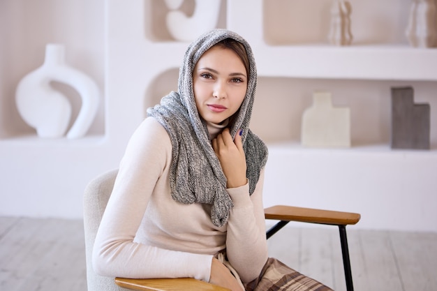 Smiling islam woman in hijab sits in lounge