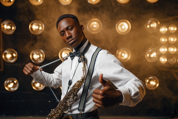 Smiling jazz performer with saxophone on stage