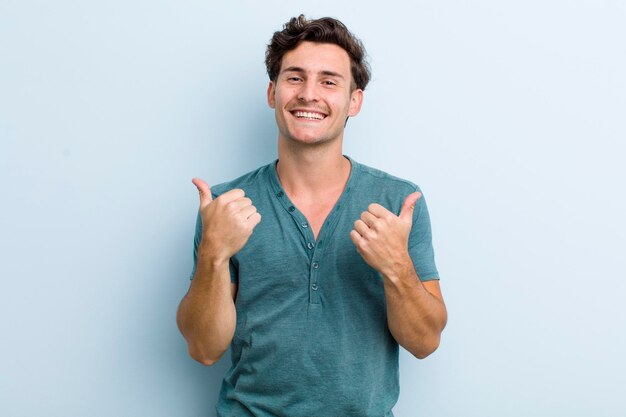 Sorridere con gioia e sembrare felice sentendosi spensierato e positivo con entrambi i pollici in su