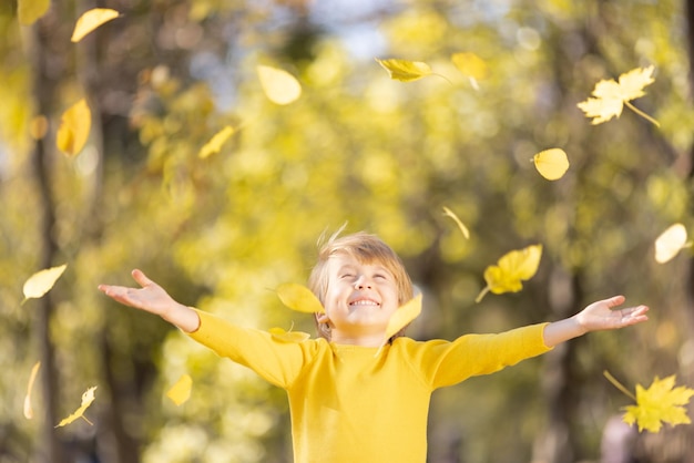 Smiling kid having fun outdoor in autumn par