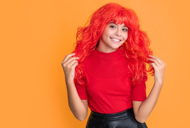 Smiling kid with red long hair on yellow background