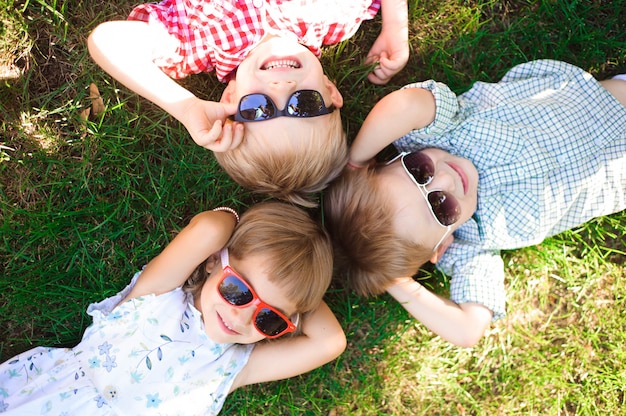 Smiling kids at the garden in sunglasses