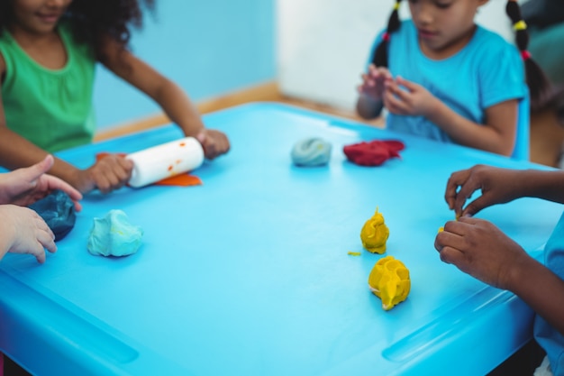 Smiling kids using modelling clay