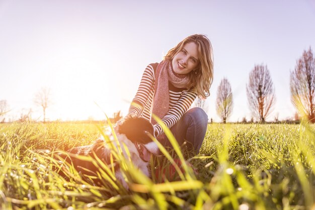 Smiling lady taking free time with her dog