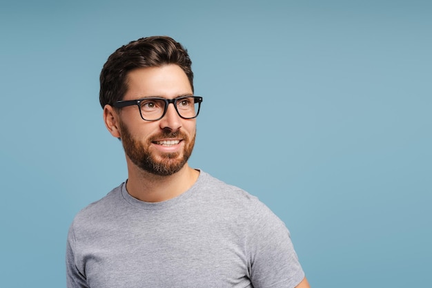 Smiling Latin man wearing stylish eyeglasses blue shirt looking away vision treatment concept