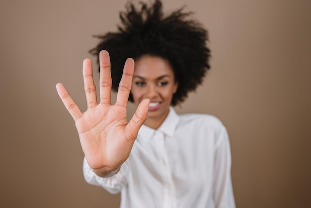 Smiling Latin woman making five countdown times sign gesture with hand fingers on pastel background