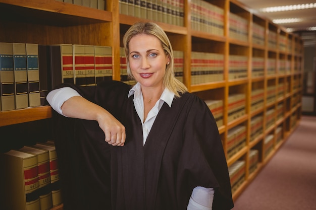 Photo smiling lawyer leaning on shelf