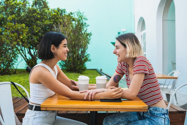 Фото Улыбающиеся лесбиянки наслаждаются кофе на столе.