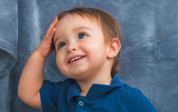 The smiling little boy posing on camera